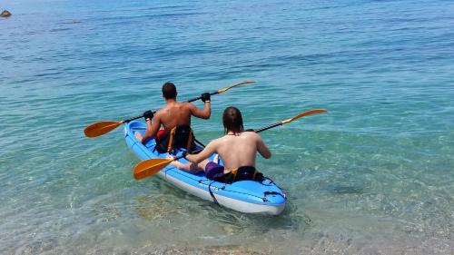 a man and a woman in a kayak in the water at Nicopolis Villa in Vráchos