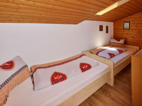 two beds in a room with wooden ceilings at Haus Raimund in Längenfeld