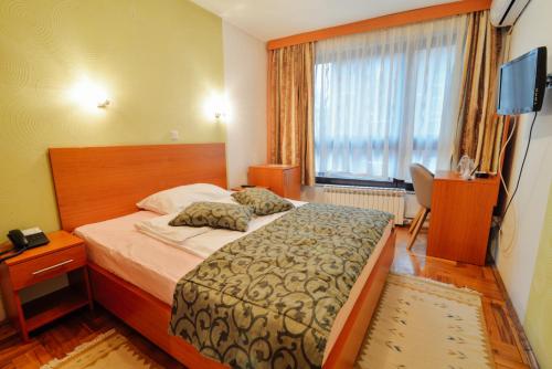 pokój hotelowy z łóżkiem i oknem w obiekcie Hotel Mod w Sarajewie