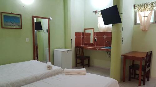 a bedroom with two beds and a sink and a mirror at Hotel Iker in Tulum