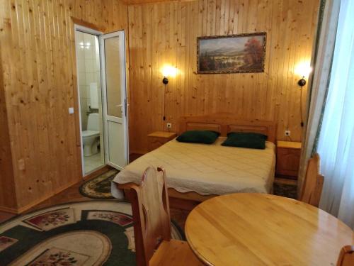 a bedroom with a bed and a table and a mirror at Яблучко in Yaremche