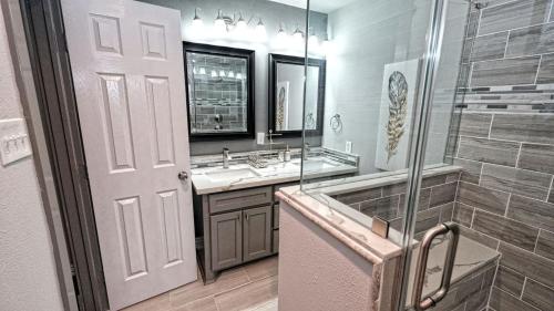 een badkamer met een douche, een wastafel en een spiegel bij NRG, Medical Center, Galleria, Energy Corridor, MD Anderson - 15206 in Missouri City