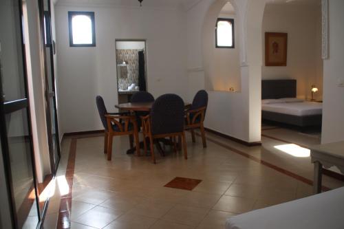 ein Esszimmer mit einem Tisch, Stühlen und einem Bett in der Unterkunft Chez Fatima et Hervé in Somone