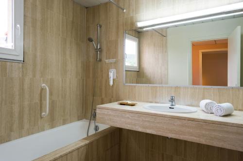 a bathroom with a sink and a mirror at Logis Hôtel Cartier in Quillan