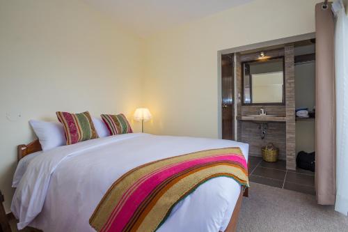 a bedroom with a bed with a mirror and a sink at Luna House Cusco in Cusco
