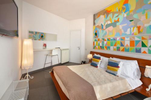 ナポリにあるLA LOCANDA DELL'ARTE-DE GASPERIのベッドルーム1室(壁に絵画が描かれたベッド1台付)