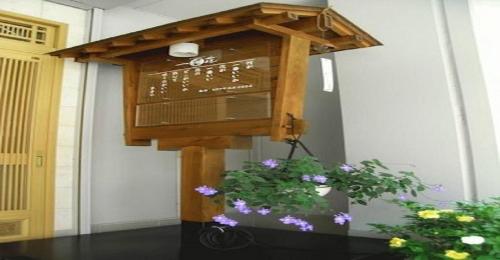 un cartello sul lato di un edificio con fiori di Ichigekan / Vacation STAY 8473 a Shima