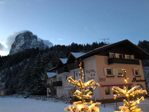 a hotel with christmas lights in front of a mountain at B&B MARINA contacless check in in Santa Cristina in Val Gardena