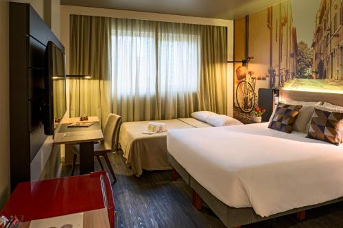 a hotel room with two beds and a desk at Novotel Curitiba Batel in Curitiba