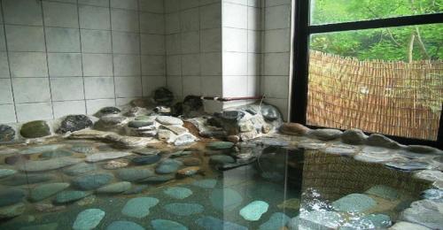 a room with a pool of rocks and a window at Ichigekan / Vacation STAY 8470 in Nakanojo