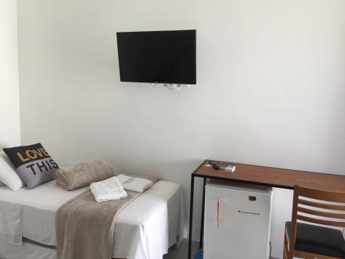 um quarto com uma cama e uma televisão na parede em Pousada CasaPark em Penha