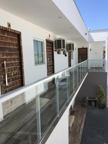 a balcony of a house with glass railing at Pousada CasaPark in Penha