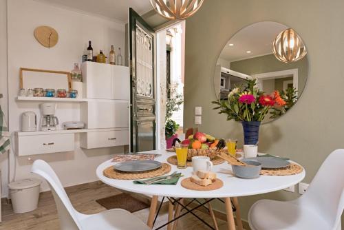 a dining room with a white table and a mirror at Artemis Apartment in Corfu Town