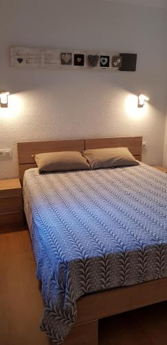 a bedroom with a bed with blue sheets and two lights at Soldeu Paradis Soldeu in Soldeu