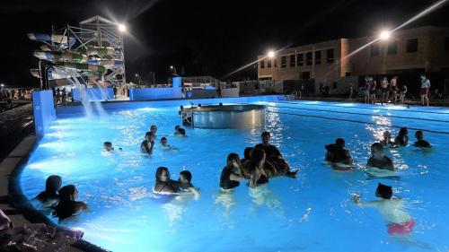 a group of people in a swimming pool at night at Gościniec ELLA INN Lipniki in Lipniki