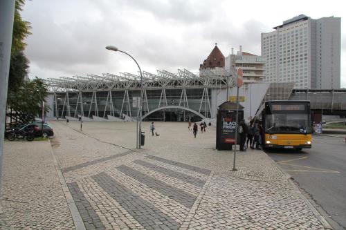 a yellow bus is parked at a bus stop at 7Rios Rooms in Lisbon