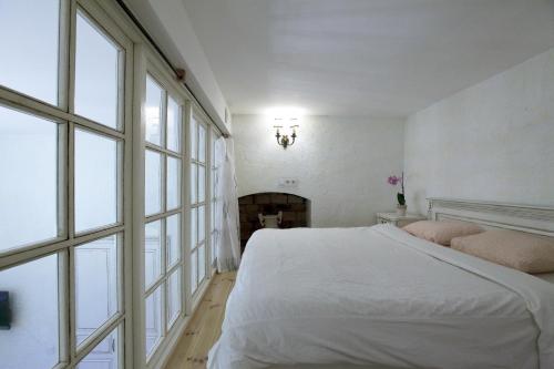 Un dormitorio blanco con una cama y una chimenea. en Provence Home, en Vilna