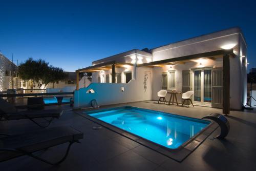 a villa with a swimming pool at night at Aeris suites in Koufonisia