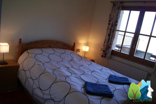 a bedroom with a large bed with blue pillows at Soldeu Paradis Soldeu in Soldeu