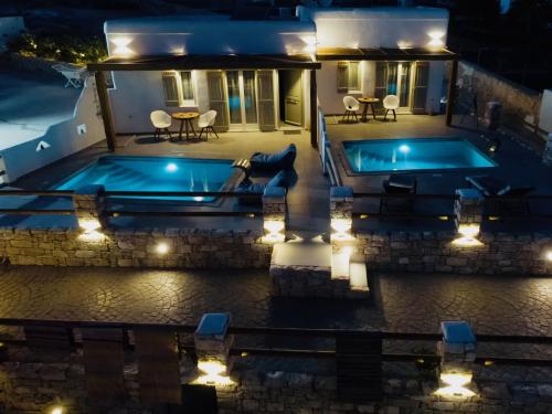 a house with a swimming pool at night with lights at Aeris suites in Koufonisia