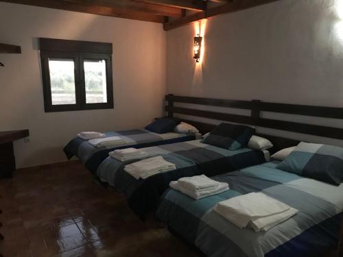pokój z 3 łóżkami i ręcznikami w obiekcie VTAR Don Benito, su casa rural en Gilena w mieście Gilena