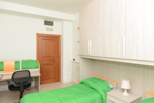 una camera con letto verde e scrivania di Da Mimì a Napoli