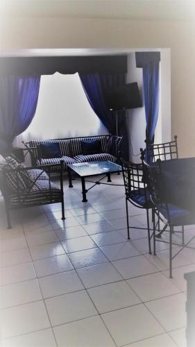 a room with chairs and a piano and blue curtains at Apart Antofagasta in Antofagasta