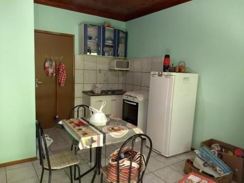 una pequeña cocina con mesa y nevera en JOÃO CARLOS CASAS KIT 1 Verde, en Penha