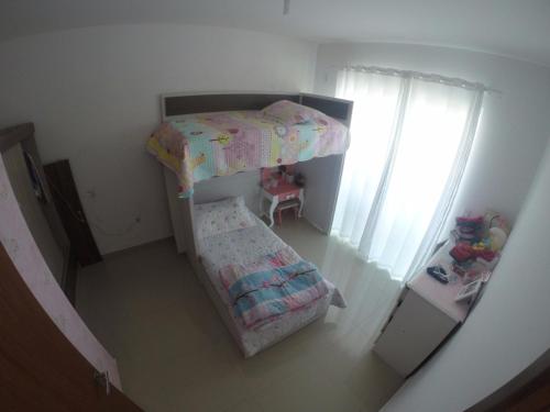 a small bedroom with a bunk bed and curtains at Casa Mobiliada Praia do Gravata in Navegantes