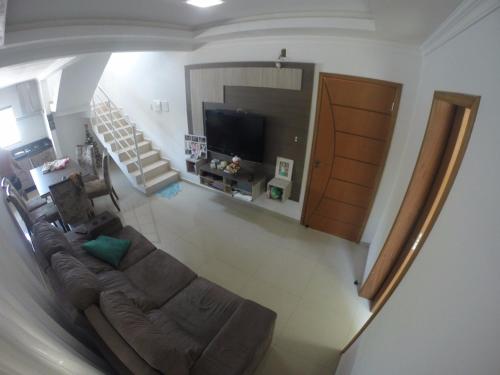 a living room with a couch and a television at Casa Mobiliada Praia do Gravata in Navegantes