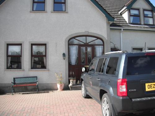 a suv parked in front of a house at Narrow Gauge B&B in Ballymoney