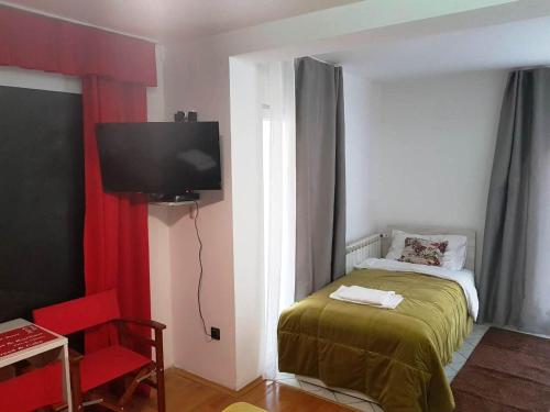 a bedroom with a bed and a tv on the wall at Villa Borak Sarajevo in Sarajevo