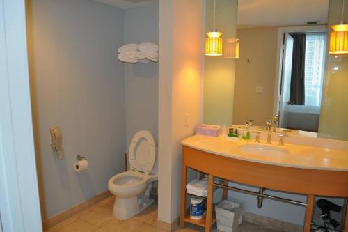 a bathroom with a sink and a toilet and a mirror at Marenas 2 Bed 907 in Miami Beach