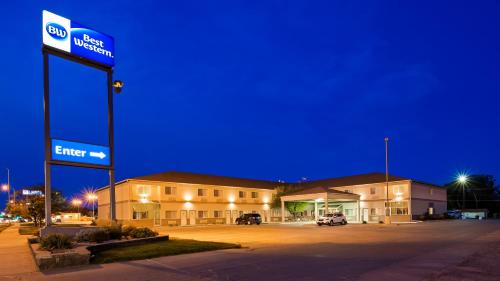 un edificio con un cartel en un estacionamiento por la noche en Best Western Of Huron, en Huron