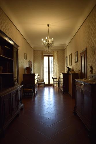 a living room with a chandelier and a dining room at Villa Storica Calderino in Monte San Pietro