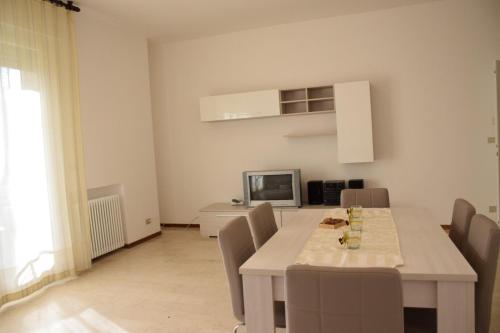 a white dining room with a table and chairs at Appartamento Giuliana Cervia in Cervia
