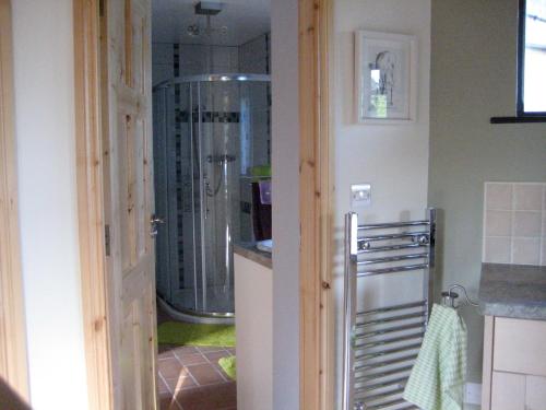 Habitación con baño con ducha a ras de suelo. en Drombrow Cottage en Bantry