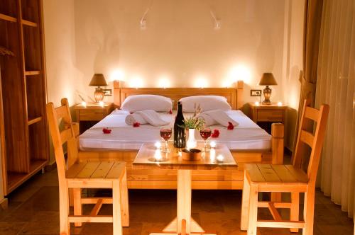ダッチャにあるDoada Hotelのベッドルーム1室(ベッド2台、ワイングラス付きのテーブル付)