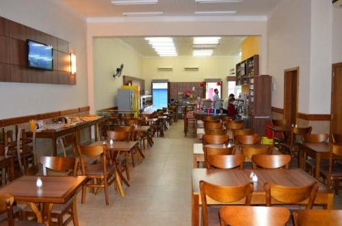 um restaurante cheio de mesas e cadeiras de madeira em Hotel Artisan em Jaguarão