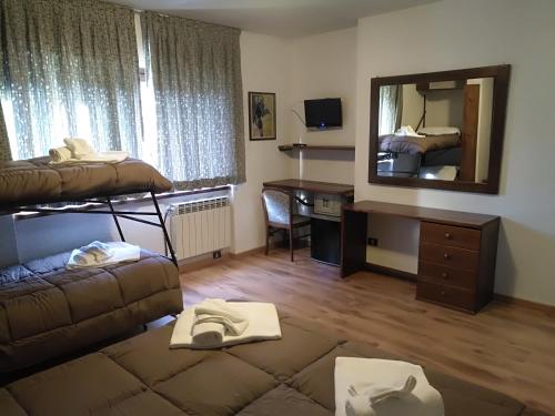 a room with a bed and a desk and a mirror at Hotel I Larici in Bardonecchia