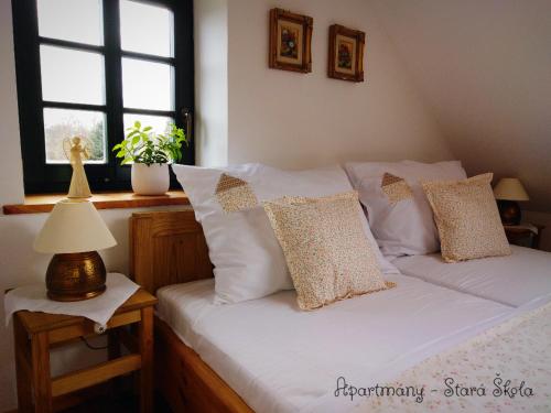 a bed with white sheets and pillows in a bedroom at Apartmány Stará Škola in Krásná Lípa