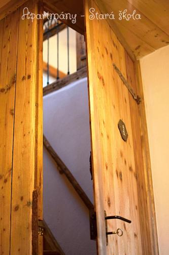 a refrigerator in a room with a wooden wall at Apartmány Stará Škola in Krásná Lípa