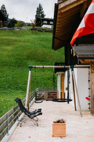 a swing on a porch of a house at Mönch Amazing Apartment Grindelwald in Grindelwald