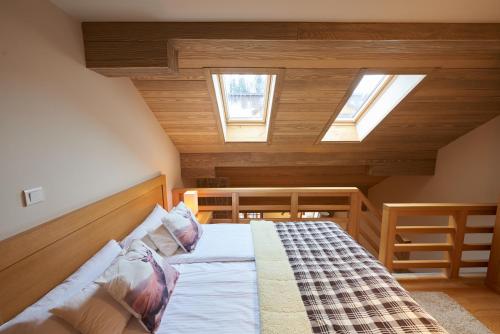 a bedroom with a bed with two skylights at Apartment 411 Vucko in Jahorina