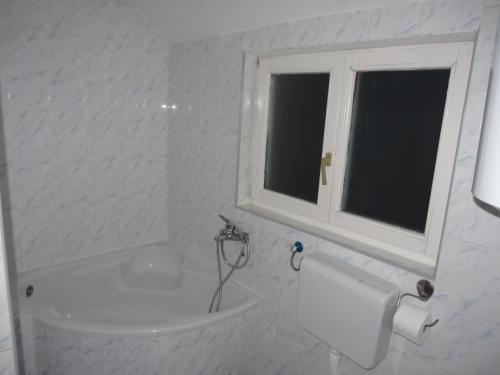 a bathroom with a tub and a toilet and a window at Leo in Niš
