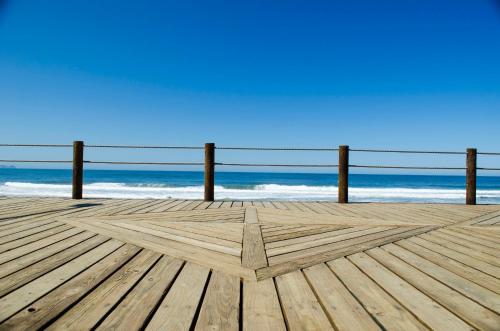 a wooden boardwalk with the beach in the background at Beachfront Charming 1 Bdr 1 Bth in Tijuana