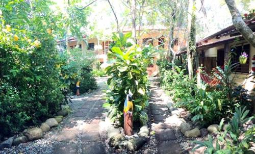 a garden with a stone walkway in front of a house at Hotel Tropical Sands Dominical in Dominical