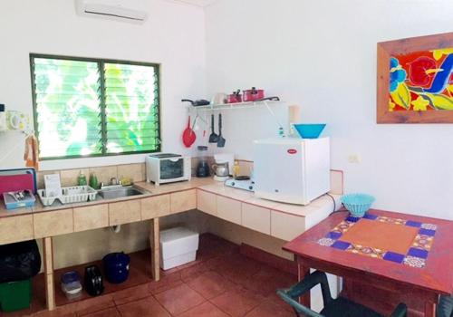 a kitchen with a sink and a counter with a microwave at Hotel Tropical Sands Dominical in Dominical