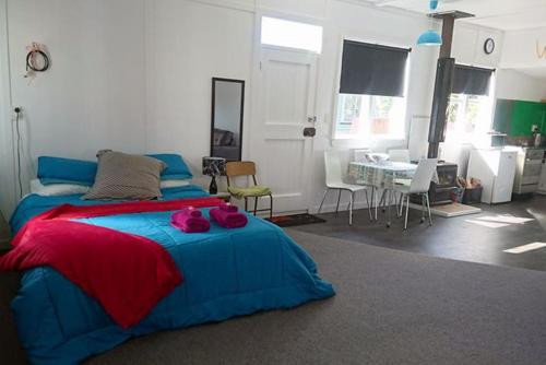 a bedroom with a large bed and a dining room at Whanga Butcher Shop in Whangamomona