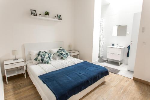 une chambre blanche avec un lit et deux tables de nuit dans l'établissement Appartement Vacances Picardie, à Amiens
